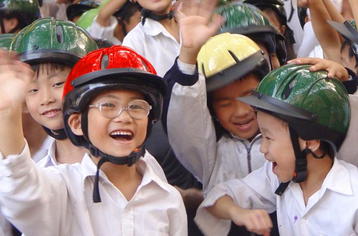 Trẻ em đội những chiếc mũ bảo hiểm do nhà máy của Quỹ AIP sản xuất. Rất nhiều nạn nhân tai nạn giao thông tại Việt Nam và các nước đang phát triển là trẻ em